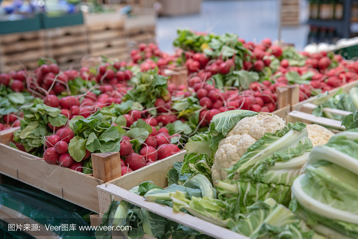 超市货架上和市场里农民用板条箱装的新鲜蔬菜。出售